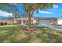 One-story house with a large tree and a paved driveway at 8478 Sw 60Th Ct, Ocala, FL 34476