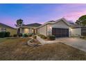 Tan house with screened garage, landscaping, and brick walkway at 7524 Sw 101St Ct, Ocala, FL 34481