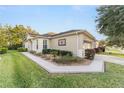 Tan house with landscaped yard, walkway, and two-car garage at 9570 Sw 70Th Loop, Ocala, FL 34481