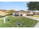 Tan house with landscaped yard, walkway, and two-car garage at 9570 Sw 70Th Loop, Ocala, FL 34481