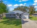 Newly built gray house with metal roof and a spacious lawn at 1166 Cr 441, Lake Panasoffkee, FL 33538