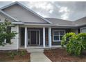 Welcoming front entry with a covered porch, stone accents, and a dark wood door at 444 Ne 63Rd St, Ocala, FL 34479