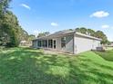 Backyard view showcasing a screened-in patio and lush green lawn at 8342 Sw 65Th Ave, Ocala, FL 34476