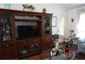 Living room with wood floors, a large entertainment center, and comfortable seating at 11581 Sw 78Th Ave, Ocala, FL 34476