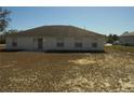 Rear view of a single-story home with a large backyard and patio at 4725 Sw 100Th St, Ocala, FL 34476