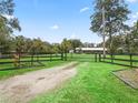 Long driveway leads to a home with a black metal gate at 3505 Ne 97Th Street Rd, Anthony, FL 32617