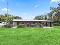 Ranch-style home with a covered porch and manicured lawn at 3505 Ne 97Th Street Rd, Anthony, FL 32617