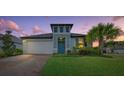 Charming two-story home with a welcoming front porch and landscaped yard at dusk at 3810 Se 4Th Ter, Ocala, FL 34480