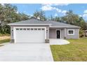 New construction home, gray exterior, white garage door, black front door at 39926 Parkinsonia St, Lady Lake, FL 32159