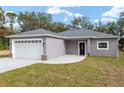 Newly built gray house with white garage door and black front door at 39926 Parkinsonia St, Lady Lake, FL 32159