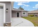 Front entrance of a new home with gray exterior and black door at 39926 Parkinsonia St, Lady Lake, FL 32159