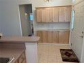 View of kitchen with wood cabinets and access to another room at 10913 Sw 69Th Cir, Ocala, FL 34476