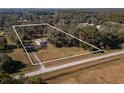 Aerial view showing a house on a large lot with surrounding trees and a road at 15620 Nw 112Th Ave, Reddick, FL 32686