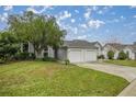 House exterior showcasing a two-car garage and lush landscaping at 2505 Se 18Th Cir, Ocala, FL 34471