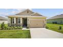 Tan one-story house with stone accents and a two-car garage at 6243 Sw 89Th Street Rd, Ocala, FL 34476