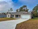 New construction home with a concrete driveway and landscaping at 6300 Sw 144Th Lane Rd, Ocala, FL 34473