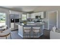 Modern kitchen with island, granite countertops, and stainless steel appliances at 115 Guava Place Dr, Ocklawaha, FL 32179