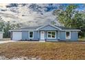 New construction home with blue exterior, white garage door, and stone accents at 16919 Sw 27Th Ave, Ocala, FL 34473