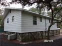 Side view of an elevated home showcasing the home's siding and foundation at 17935 Se 10Th Pl, Silver Springs, FL 34488