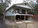 Side view of an elevated home with a large screened porch and parking at 17935 Se 10Th Pl, Silver Springs, FL 34488