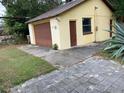 Detached garage with brown doors and side door at 1855 Ne 23Rd St, Ocala, FL 34470