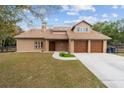 Two-story house with brown exterior, two-car garage, and a well-manicured lawn at 21959 Nw 6Th St, Dunnellon, FL 34431