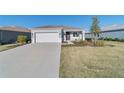 One-story house with gray exterior, two-car garage, and well-manicured lawn at 9002 Sw 75Th Loop, Ocala, FL 34481