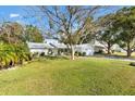 White house with gray roof and mature trees in the front yard at 10195 Se 178Th Pl, Summerfield, FL 34491