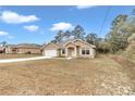 Tan house with white garage door and landscaping at 171 Oak Circle, Ocala, FL 34472