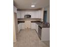 Modern kitchen with white cabinets, granite countertops, and stainless steel appliances at 5489 Nw 12Th. St, Ocala, FL 34482