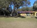 Landscaped yard with large oak trees and a chain link fence at 611 Sw Shorewood Dr, Dunnellon, FL 34431
