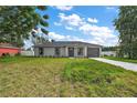 Newly built house with gray siding, dark gray garage door, and a spacious lawn at 13457 Sw 107Th Pl, Dunnellon, FL 34432