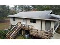 Elevated house with wooden deck and stairs, situated on a wooded lot at 16510 Se 49Th Street Road, Ocklawaha, FL 32179