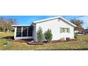 Side view of a white house with green shutters and landscaped yard at 11190 Sw 75Th Ter, Ocala, FL 34476