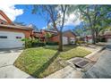 Side view of a two-story townhome with attached garage and mature trees at 2701 Ne 10Th St # 303, Ocala, FL 34470