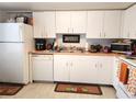 White kitchen with appliances, ample counter space, and tile flooring at 8128 Fairways Cir # R101, Ocala, FL 34472