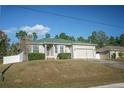 Single-story house with a green roof, attached garage, and a well-maintained lawn at 8457 Sw 138Th Pl, Ocala, FL 34473