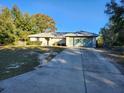Single-story house with attached garage and a long driveway at 113 Guava Ter, Ocklawaha, FL 32179