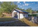 Detached garage with brown door, located in a yard with trees at 11360 Se 188Th Ave, Ocklawaha, FL 32179