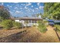 White house exterior with screened porch, surrounded by trees and yard at 11360 Se 188Th Ave, Ocklawaha, FL 32179