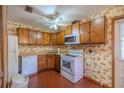 Retro kitchen with wood cabinets, white appliances, and brick floor at 11360 Se 188Th Ave, Ocklawaha, FL 32179