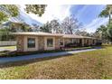 Charming stone house with a metal roof, mature trees, and a wide driveway at 2528 Se 15Th St, Ocala, FL 34471