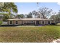 Stone house with a metal roof, large windows, and a lush lawn at 2528 Se 15Th St, Ocala, FL 34471