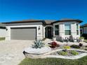 One-story home with gray garage door, paver driveway, and landscaped front yard at 8873 Sw 59Th Lane Rd, Ocala, FL 34481