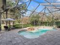 Inviting screened pool and spa with waterfall feature at 3000 Nw 79Th Avenue Rd, Ocala, FL 34482