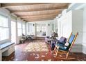 Sunroom with terracotta tile floor and rocking chairs at 1200 W Lake Otis Se Dr, Winter Haven, FL 33880