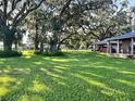 Large grassy yard with oak trees and outbuildings at 4880 Bannon Island Rd, Haines City, FL 33844