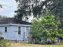 Side view of a light blue house with mature trees at 323 Dorsett Ave, Lake Wales, FL 33853