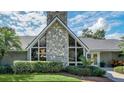 A-frame home with stone fireplace, lush landscaping and walkway at 514 Hillside Dr, Auburndale, FL 33823