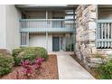 Condo building entryway, featuring stonework, landscaping, and a walkway at 2070/2071 Corner Lake Dr # 2, Haines City, FL 33844